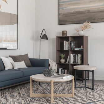 A living room coffee table with a vase, books, and a side table with a lamp.