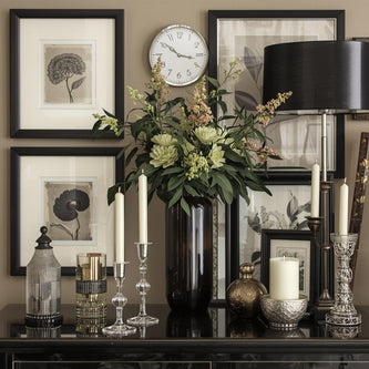 Modern wall with art, clock, and vases on a shelf.